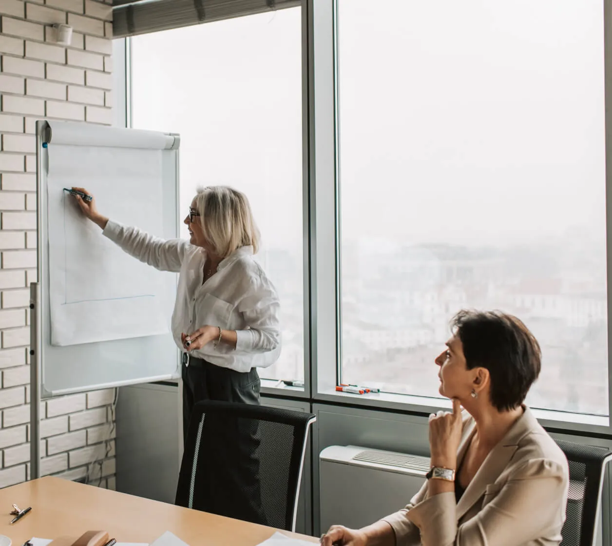 Dues professionals contrastant informació en una reunió de treball